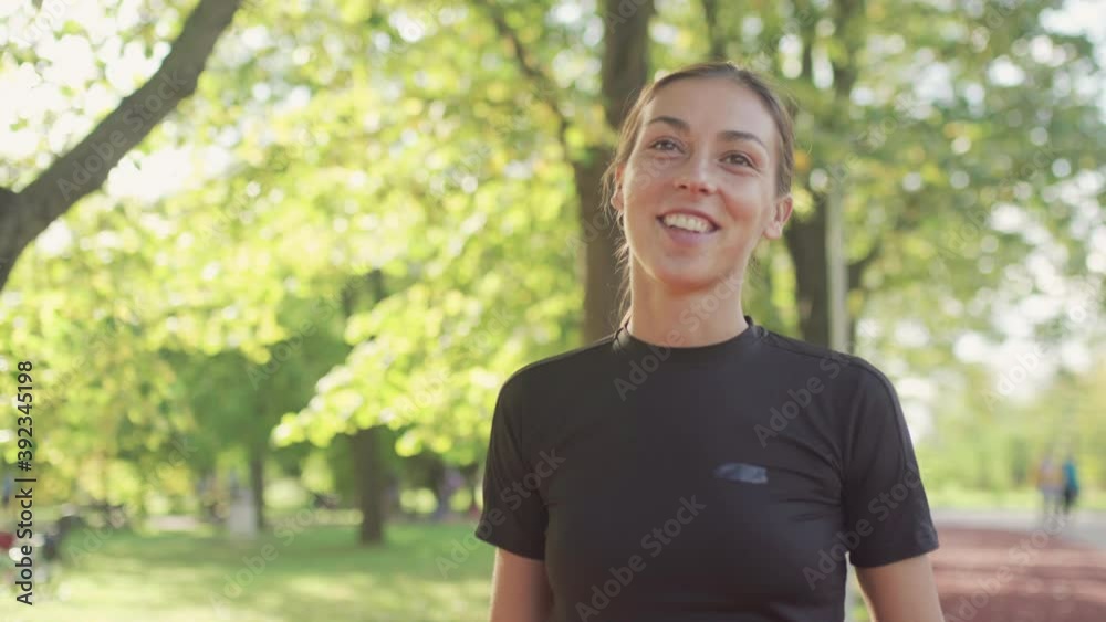 Happy fitness girl walking in the park on a sunny autumn day Happy fitness girl walking in the park on a sunny autumn day