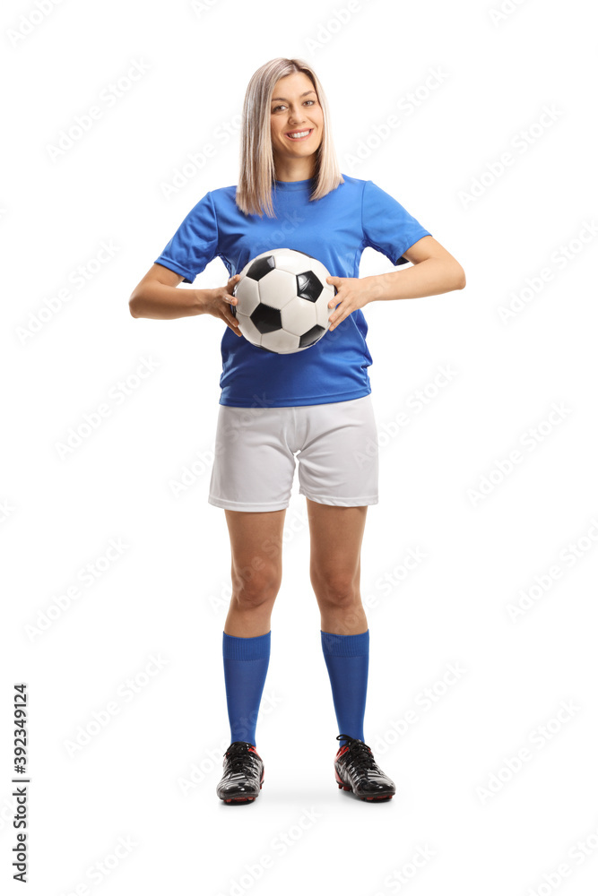 Full length portrait female soccer player smiling and holding a soccer ball