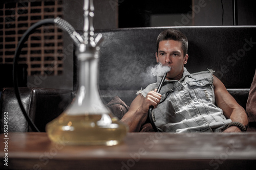 Man smoking hookah in the shisha hose. photo