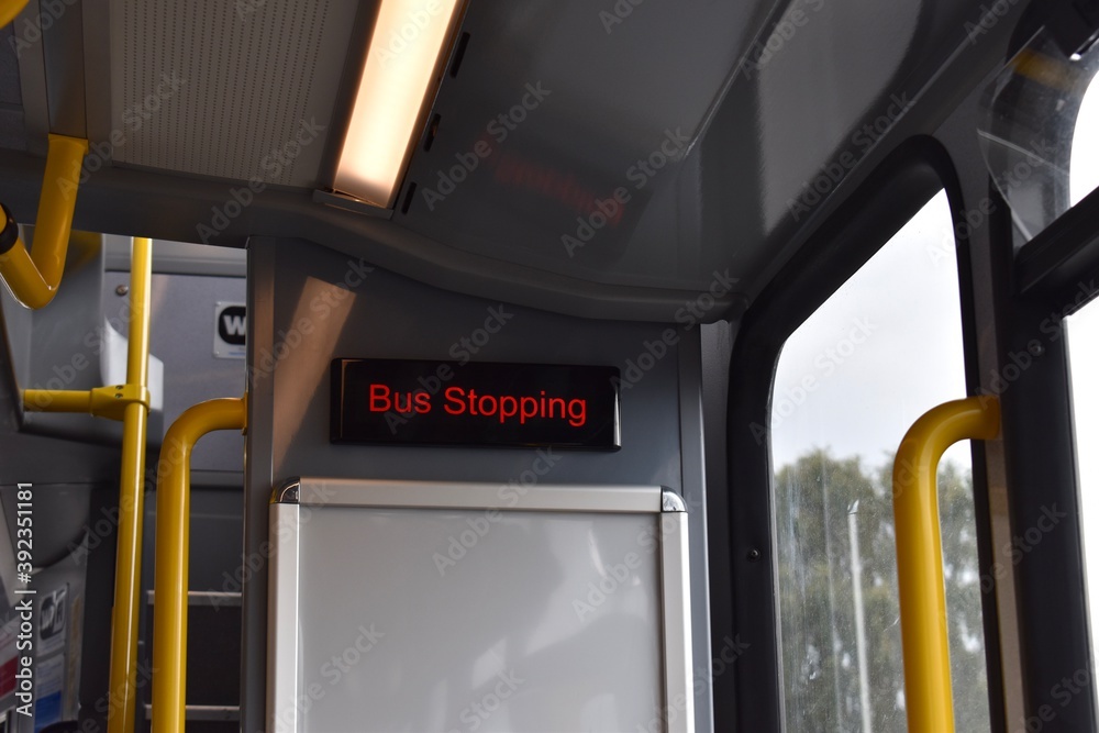 Bus Stopping sign with red letters inside a bus