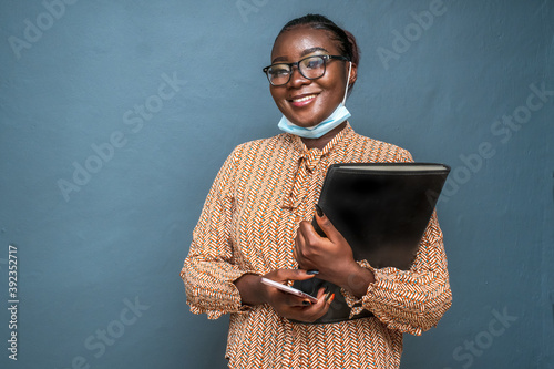 Closeup shot of a young lady holding a file of documents wearing a sanitary mask photo