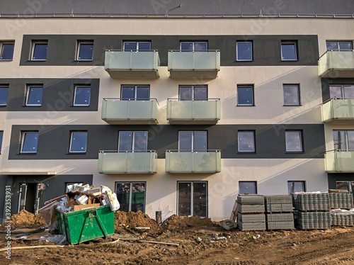 LOMIANKI, POLAND - Oct 10, 2020: Container full of rubbish standing in front of a new block of flats. photo