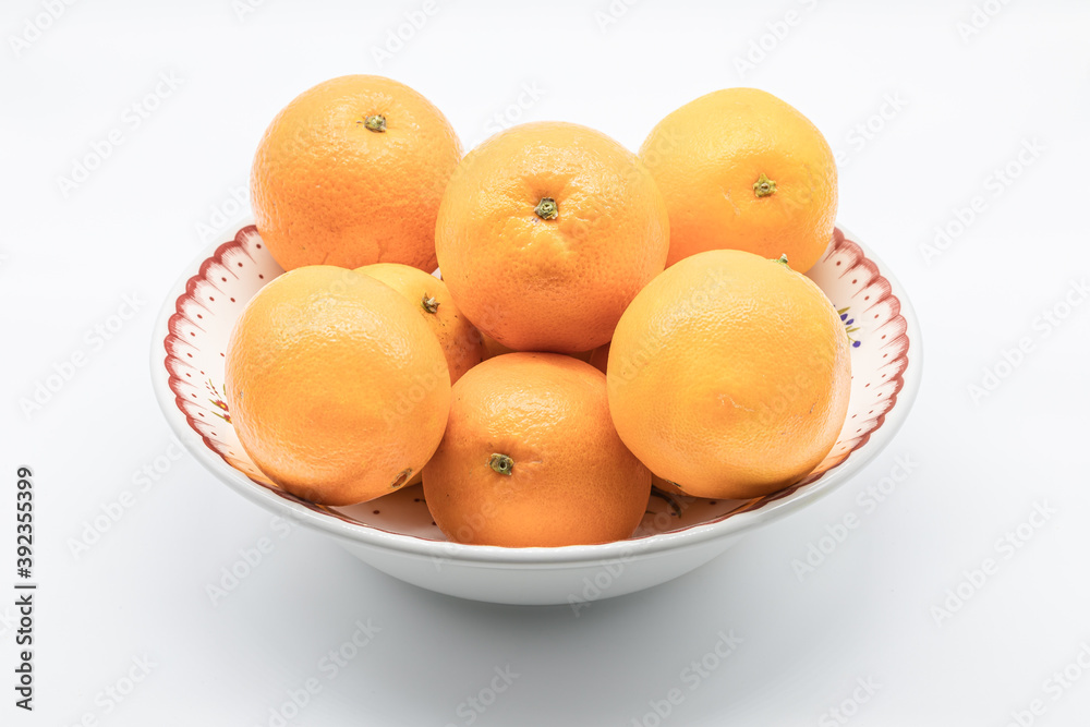Orange fruits on a porcelain source isolated on a white background Orange fruits on a porcelain source isolated on a white background