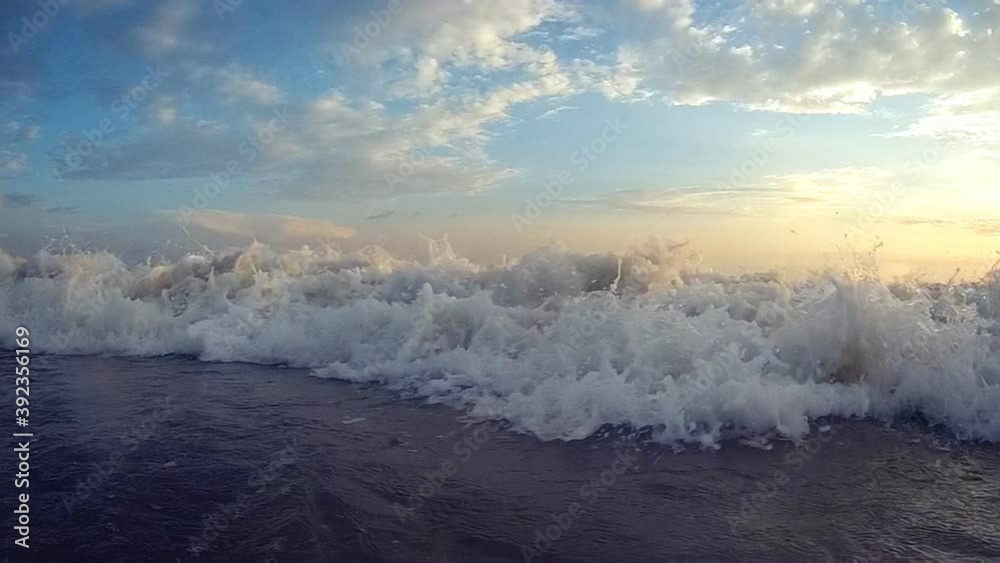 Waves crashing into camera on the beach at dusk in slow motion Waves crashing into camera on the beach at dusk in slow motion