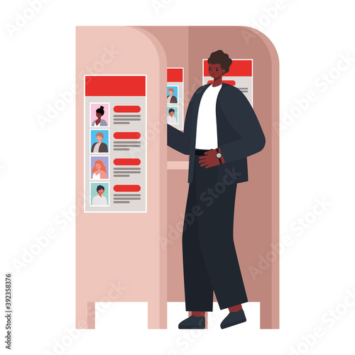 man voting with black hair and black suit in voting booth