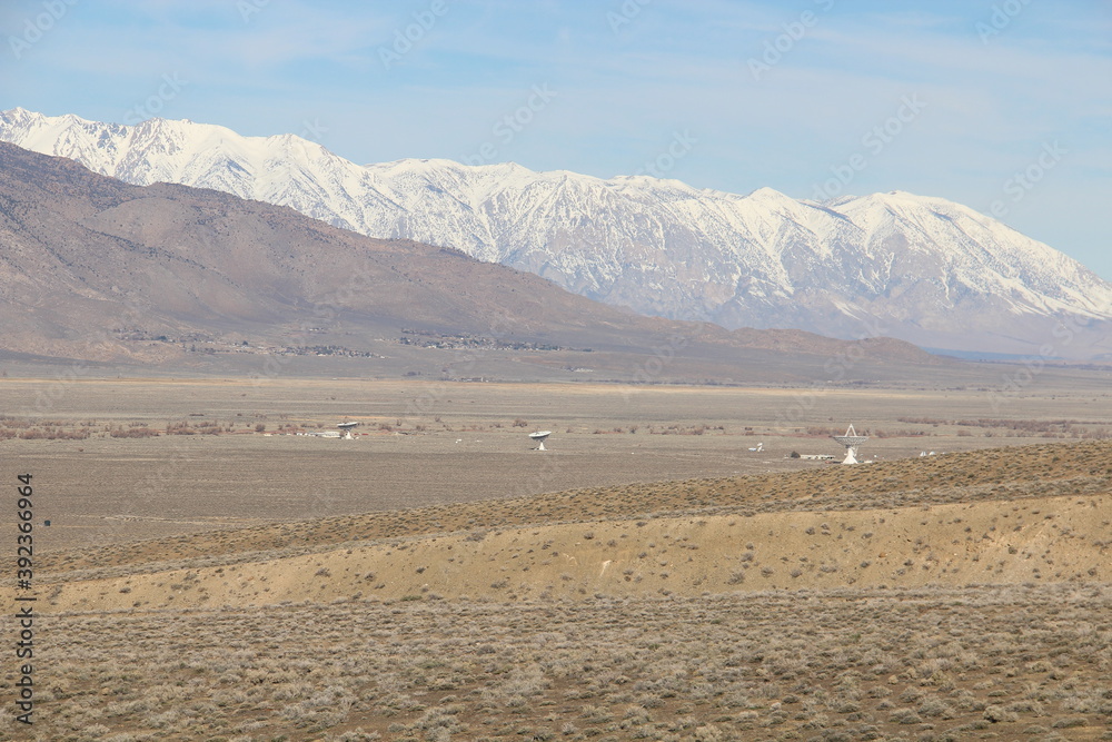 Vast of nothingness land with the big snowcapped mountains in the background.