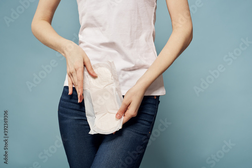 Girl with a pad on a blue background critical days menstruation hygiene appearance