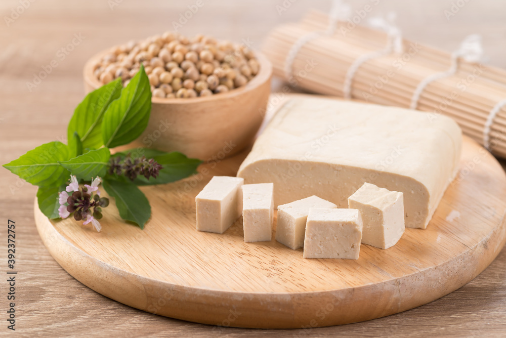 Fresh cube tofu and soybean seeds on wooden cutting board prepare for cooking, Asian vegan food