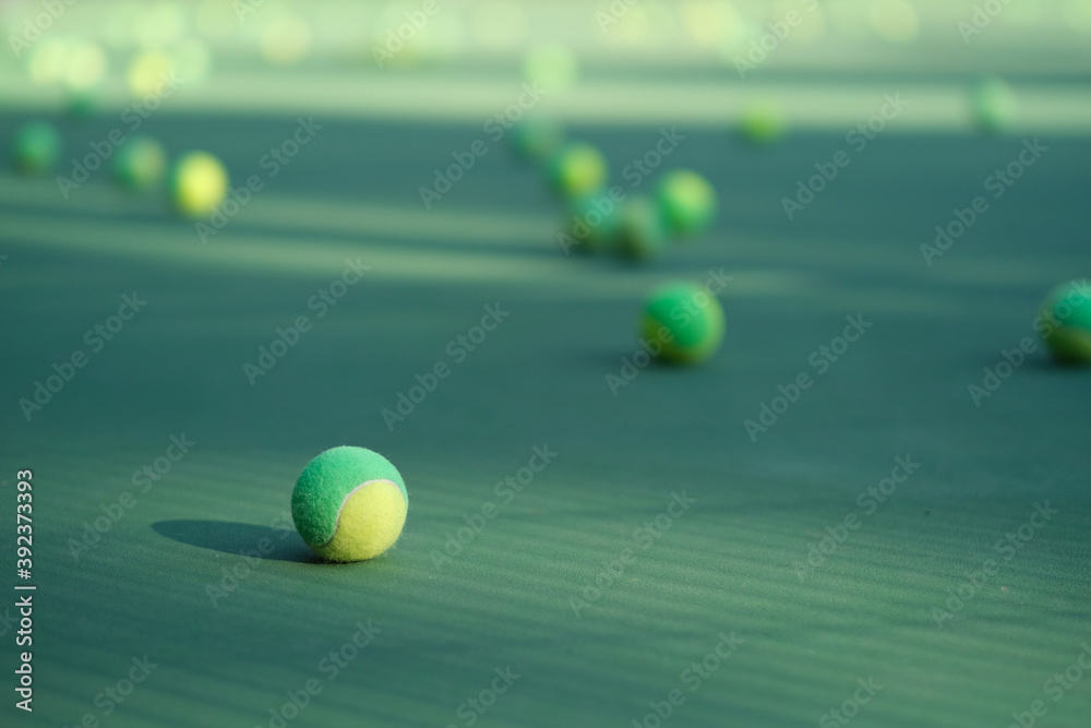 close up many tennis ball on tennis court ground under sunlight. Blur background
