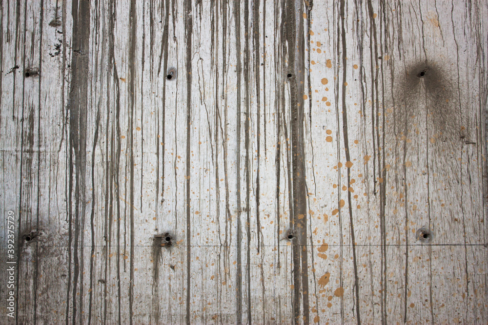 The grey color rough concrete wall with line of cement drops on its surface The grey color rough concrete wall with line of cement drops on its surface