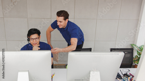 Fotografie Young handsome male customer support phone operator with headset working in call center