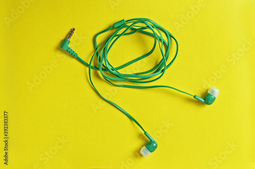 Micro-earphones for a smartphone on a yellow background close-up