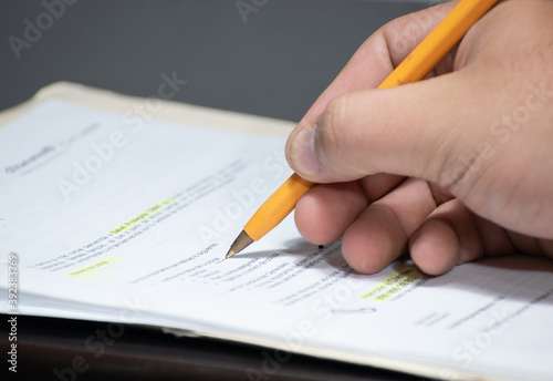 Hand of a man holding a pen over a contract
