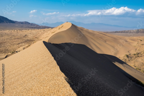 Sand dunes with clouds backgorund. Natural landscape. Altyn-Emel singing dunes or barkhan. Altyn-emel national park in Kazakhstan. Tourism travel in Kazakhstan concept.