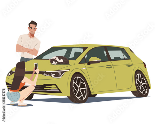 A couple shooting  a cat on a car bonnet