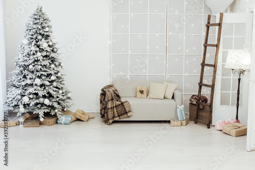 White snowy Christmas tree with gifts decor interior of the house new year postcard