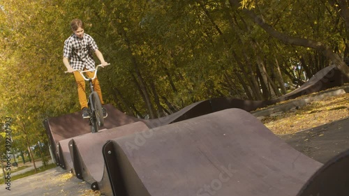 Young boy, biker riding on the pump track in the park at sunny day. Childrens sport and healthy lifestyle concept