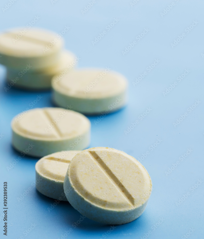 Pills are scattered on a blue background. Pills are scattered on a blue background.