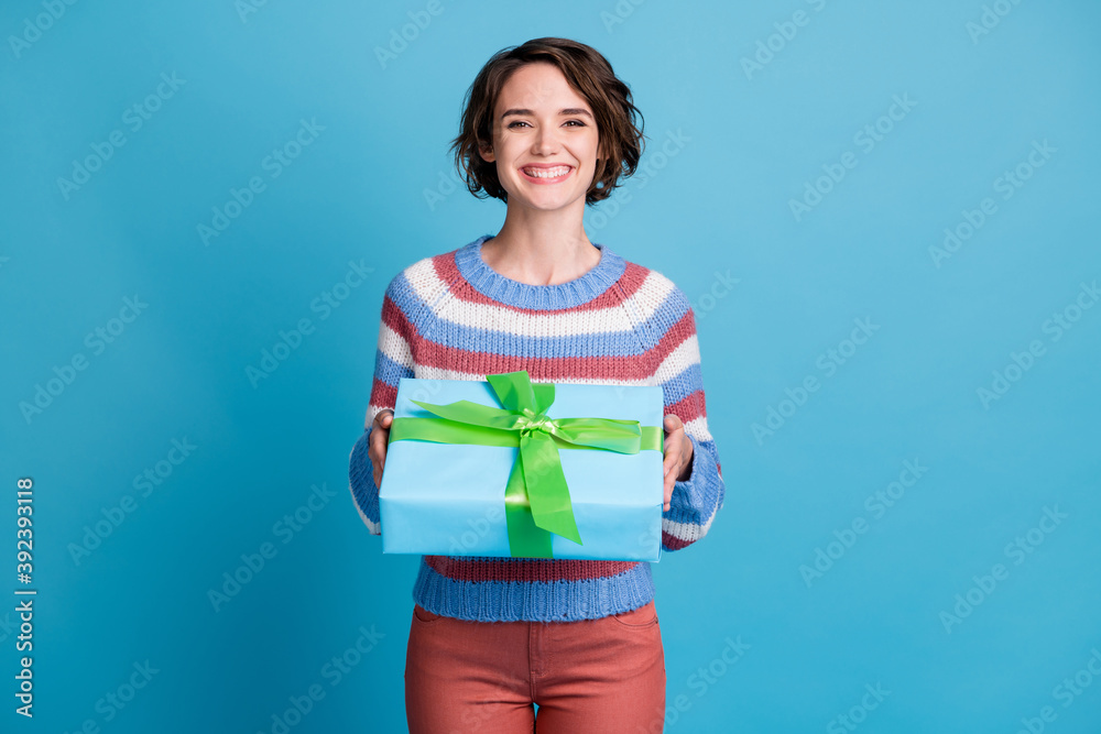 Photo portrait of cheerful girl keeping present for birthday wearing casual sweater isolated on vibrant blue color background Photo portrait of cheerful girl keeping present for birthday wearing casual sweater isolated on vibrant blue color background
