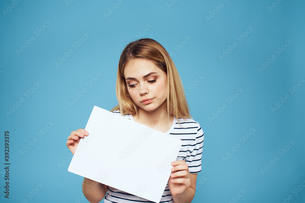 Emotional woman holding a sheet of paper in her hands lifestyle close-up blue background Copy Space Emotional woman holding a sheet of paper in her hands lifestyle close-up blue background Copy Space