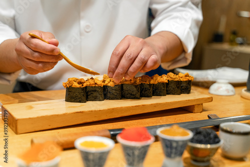 Japanese Sushi Chef making Uni Sushi. Omakase sushi course.