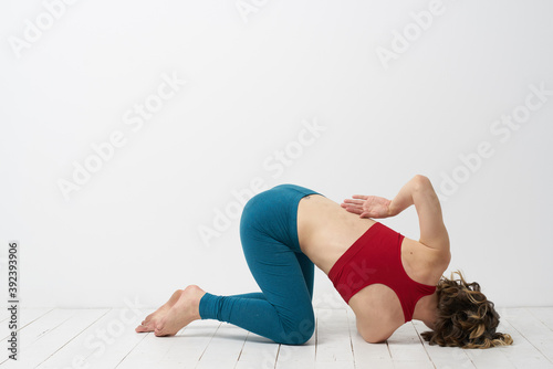 woman in leggings is engaged in gymnastics in a light room slim figure fitness sport