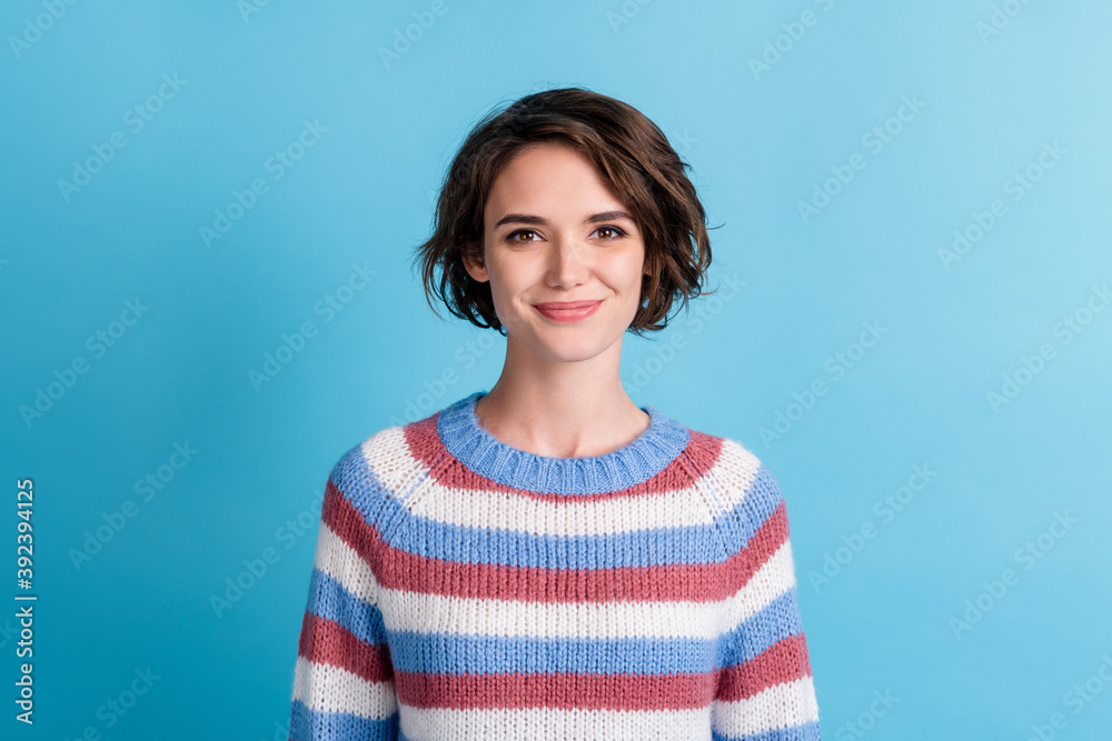 Photo of young lovely funny girl genuine smiling wear colorful striped sweater isolated blue color background Photo of young lovely funny girl genuine smiling wear colorful striped sweater isolated blue color background