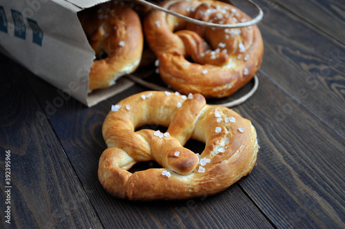 Homemade pretzels in a paper bag on a dark wooden table
