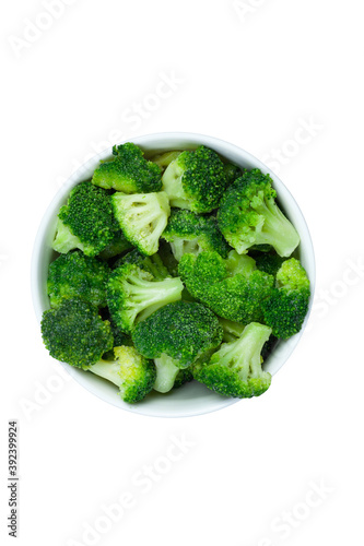 Frozen broccoli florets in a bowl isolated on white background, top view