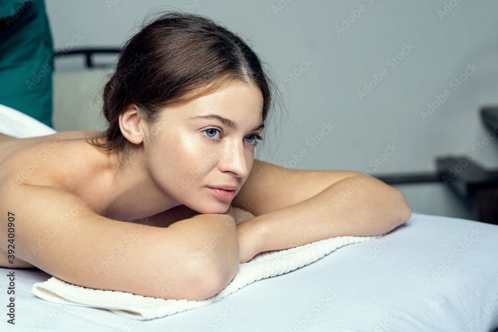 Young beautiful girl in a towel with opened eyes meditates before spa treatments Young beautiful girl in a towel with opened eyes meditates before spa treatments