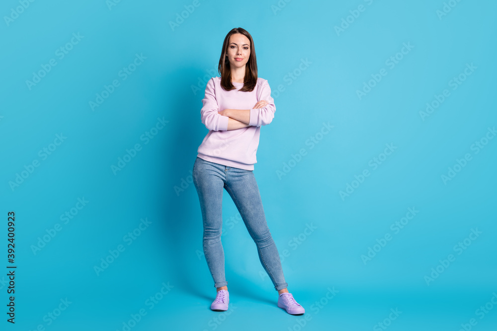 Full length photo of pretty confident bossy lady hold arms crossed manager best worker representative wear casual purple sweatshirt pullover denim jeans sneakers isolated blue color background