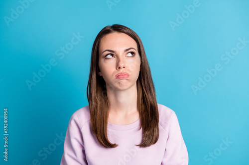 Photo of cute unsure displeased young girl puffing out cheeks look up empty space try remember how many times lend money best friend wear violet pullover isolated blue color background