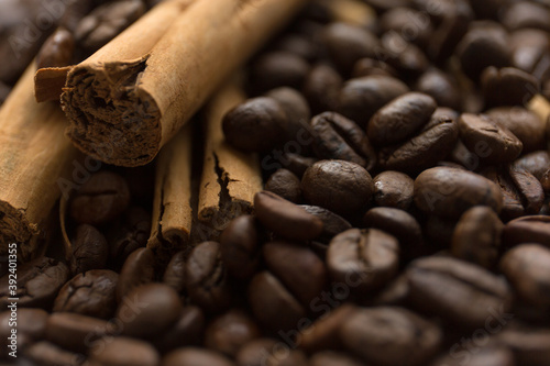 Cinnamon sticks on coffee beans blur background. Close up.
