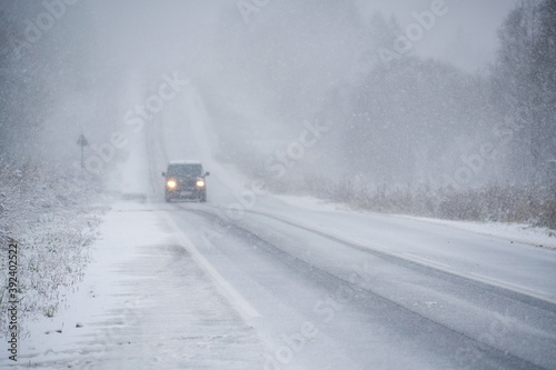 Car is driving on a winter road in a blizzard 