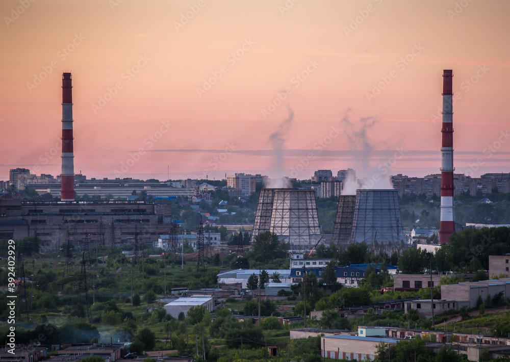 Steam power plant pipes on sunset background