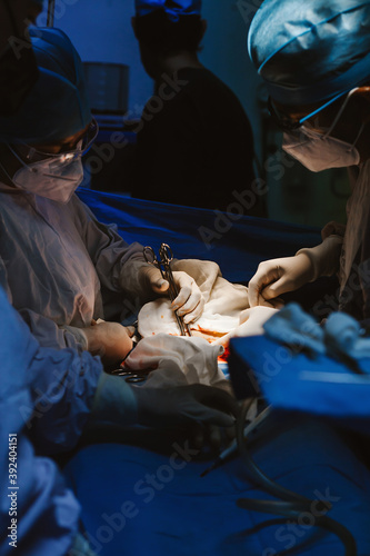 Surgeon working in operating room with scissors and other medical instruments