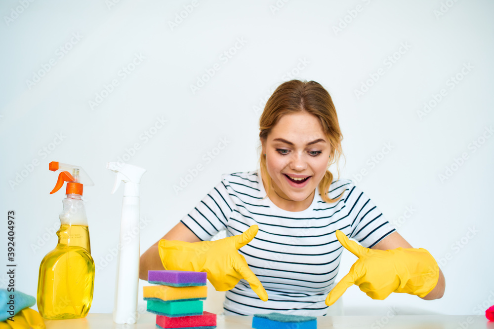 Cleaning lady in rubber gloves sits at the table cleaning tools service lifestyle Cleaning lady in rubber gloves sits at the table cleaning tools service lifestyle