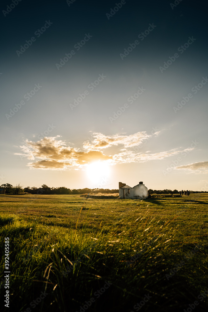 Country scene with lonely house with clouds in sunset 