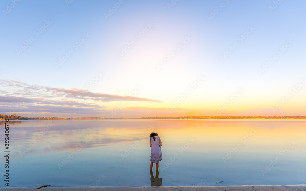 A girl in calm water river like Uyuni in the morning glow 