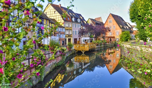 View of half timbered houses with reflection on river in Colmar, France.