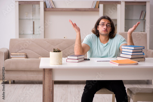 Young male student preparing for exams at home