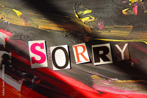 Sorry word from cut out block letters on abstract background , black and red brush strokes paint and grunge surface,   light and hard shadow dramatic effect        