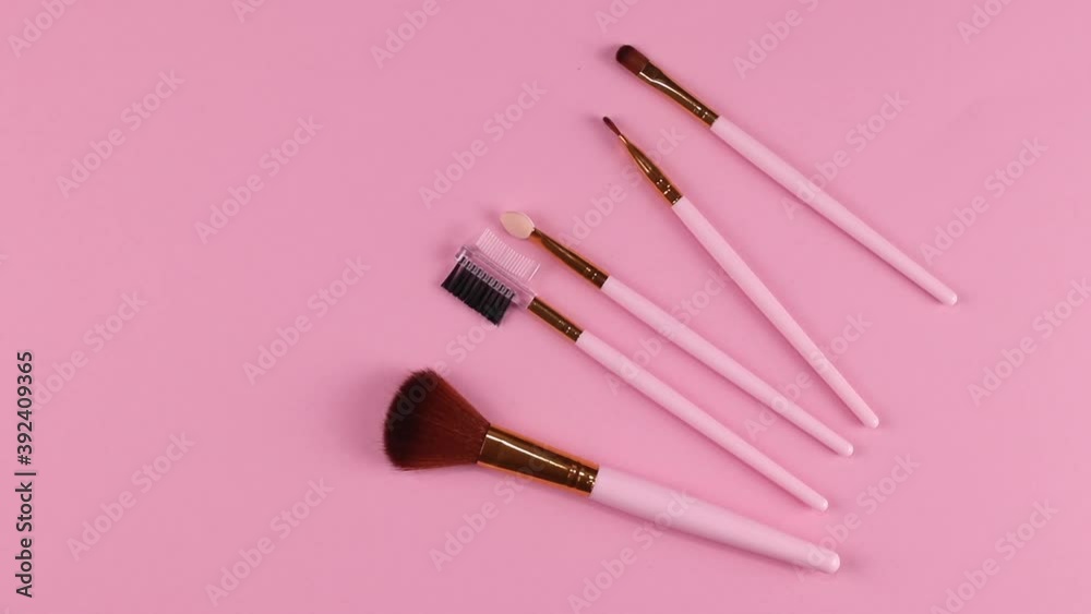 set of different makeup brushes rotating close-up against a pink background
set of different makeup brushes rotating close-up against a pink background