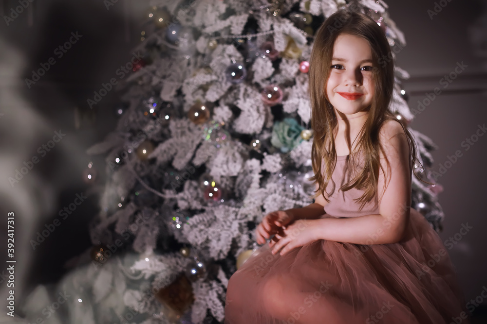 Child in smart clothes in front of the Christmas tree. New Years Eve. Waiting for the new year. Child in smart clothes in front of the Christmas tree. New Years Eve. Waiting for the new year.