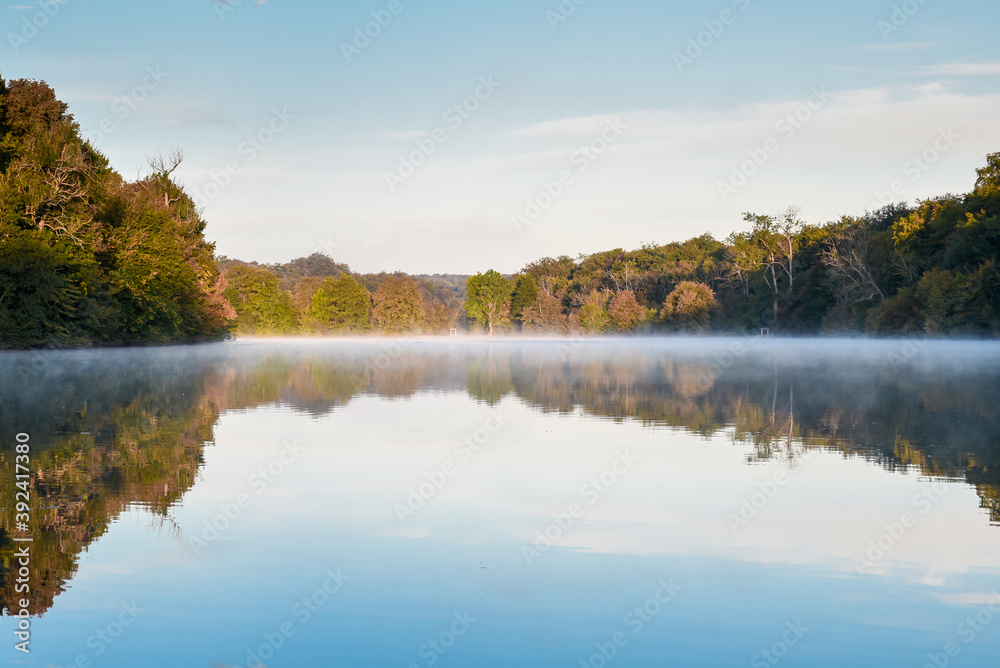 Levé de soleil et brume sur un lac avec effet miroir,  Picardie, France