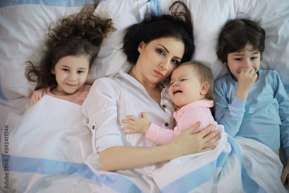 A family with children having fun on the bed under the covers during the Christmas holidays. A family with children having fun on the bed under the covers during the Christmas holidays.