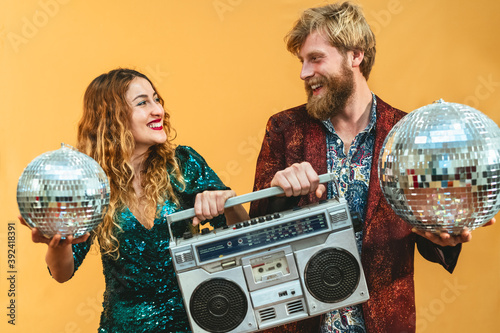 Happy young couple celebrating holidays listening music with vintage boombox