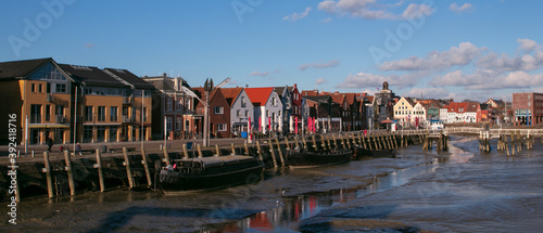 panoramic view to the lovely port of Husum with colorful housesn at low tide