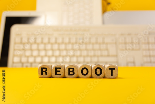 Foto The word reboot written with real wooden dices in front of a yellow background w