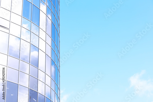 Architectural detail of the facade with multiple reflections of other buildings and the sun. Modern building. Architecture background